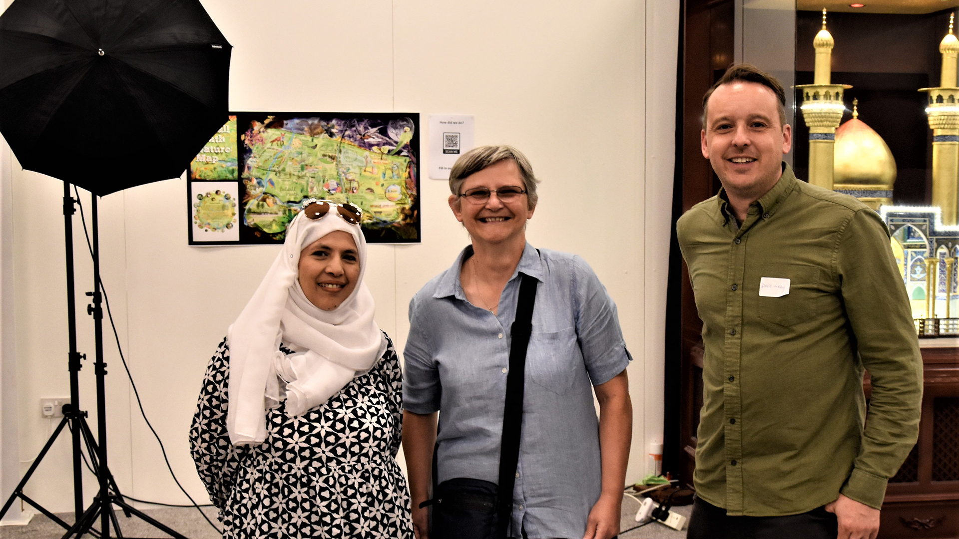 Three artists standing in front of Balsall Heath Nature Map